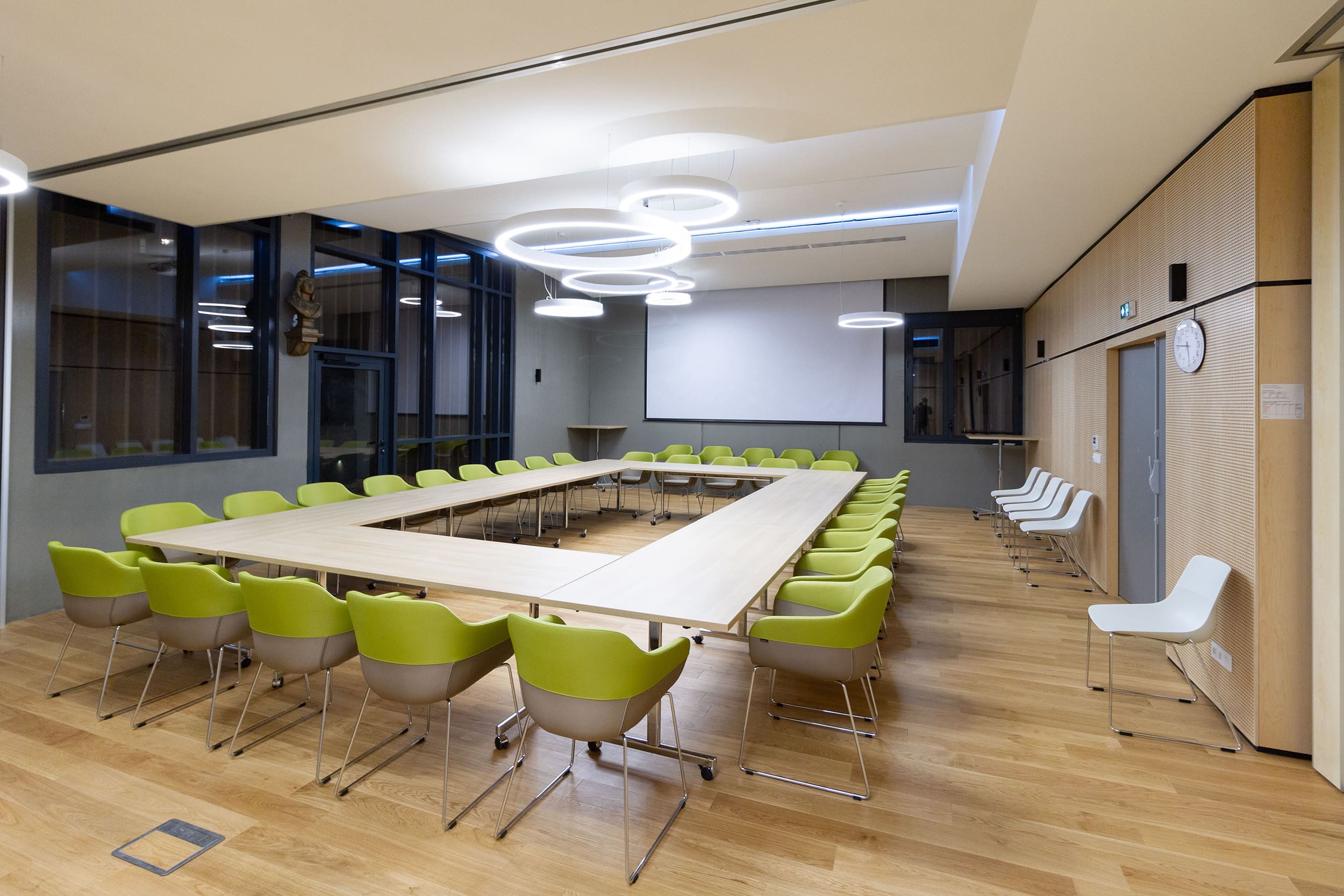 Salle de réunion pour une mairie en Savoie avec tables à plateau rabattable haut de gamme et fauteuils de conférence Design bicolore avec piétement traîneau