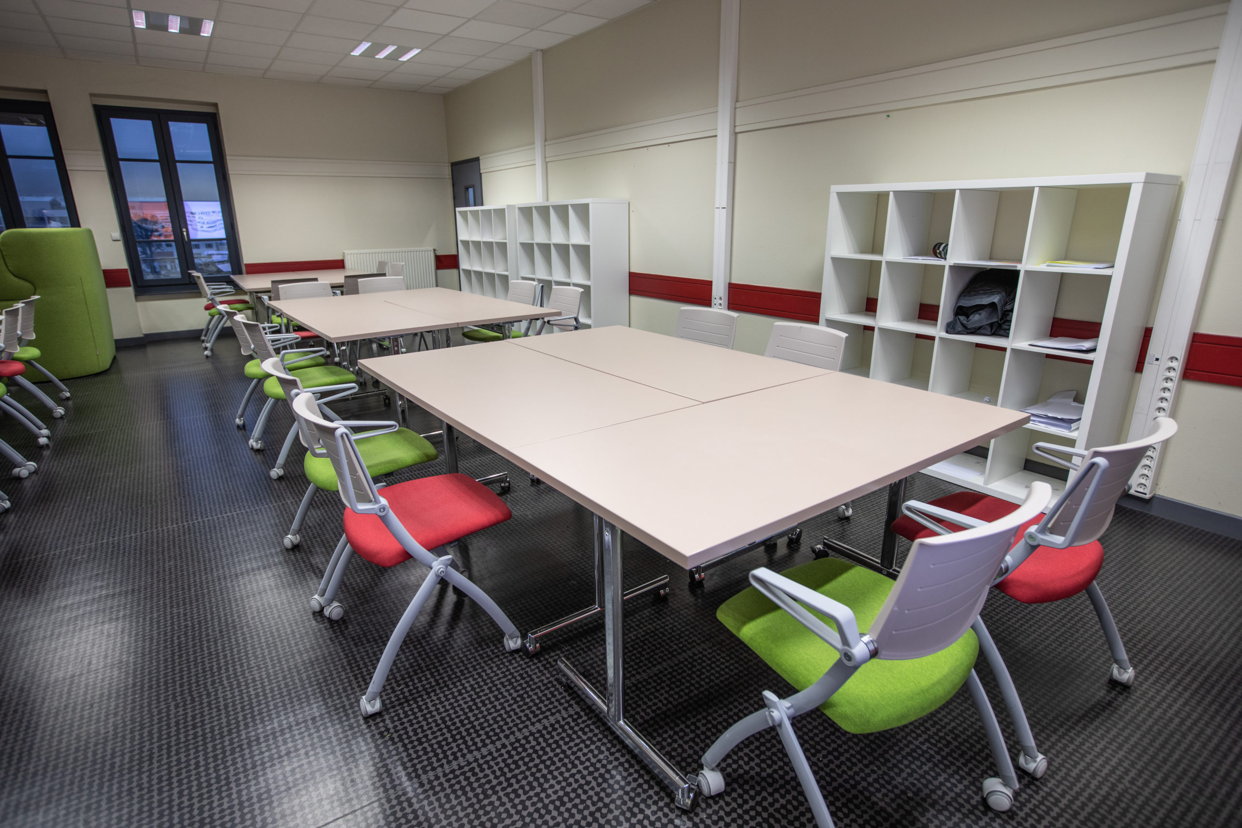 Tables à plateau rabattable avec chaises à assise rabattable dans un établissement scolaire en Isère